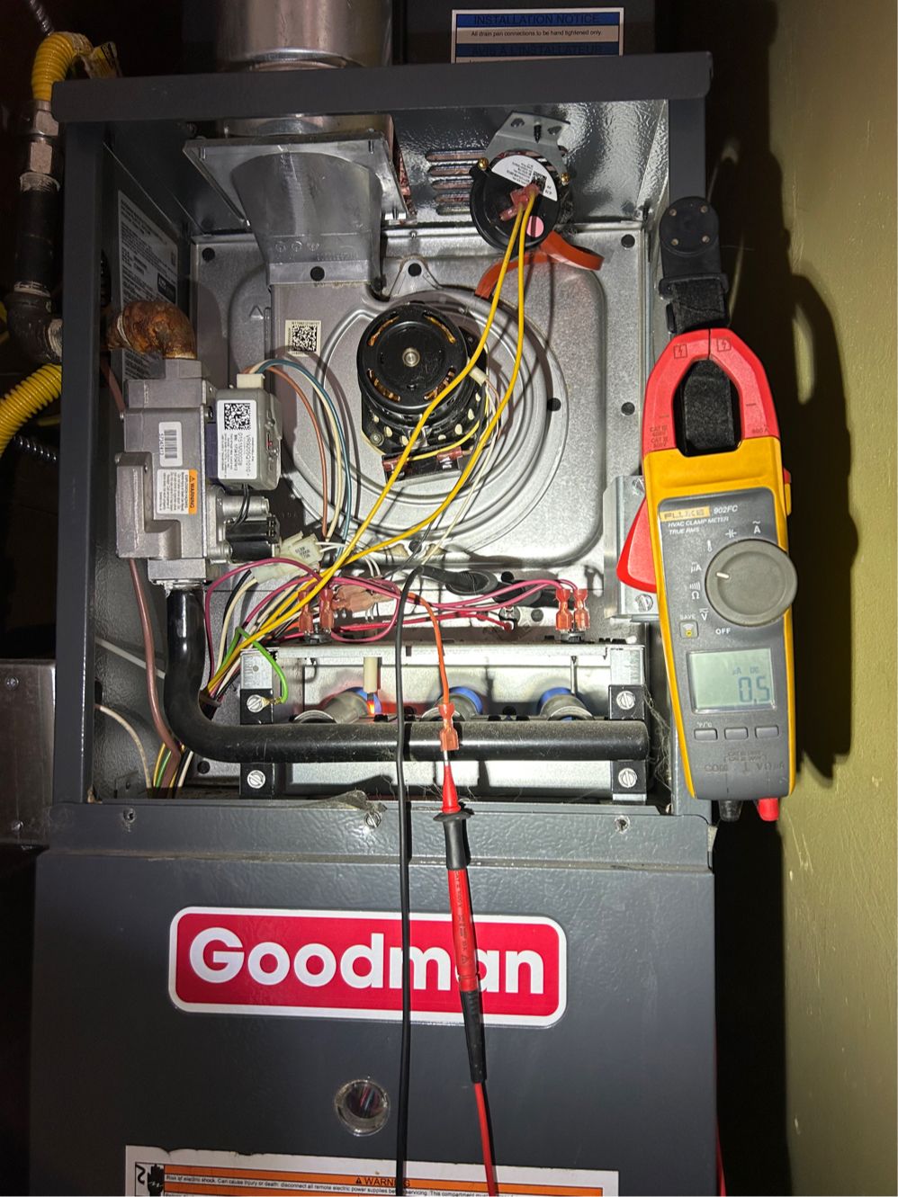 An HVAC clamp meter reading a weak 0.5 microamp flame-sensor signal on an open gas furnace