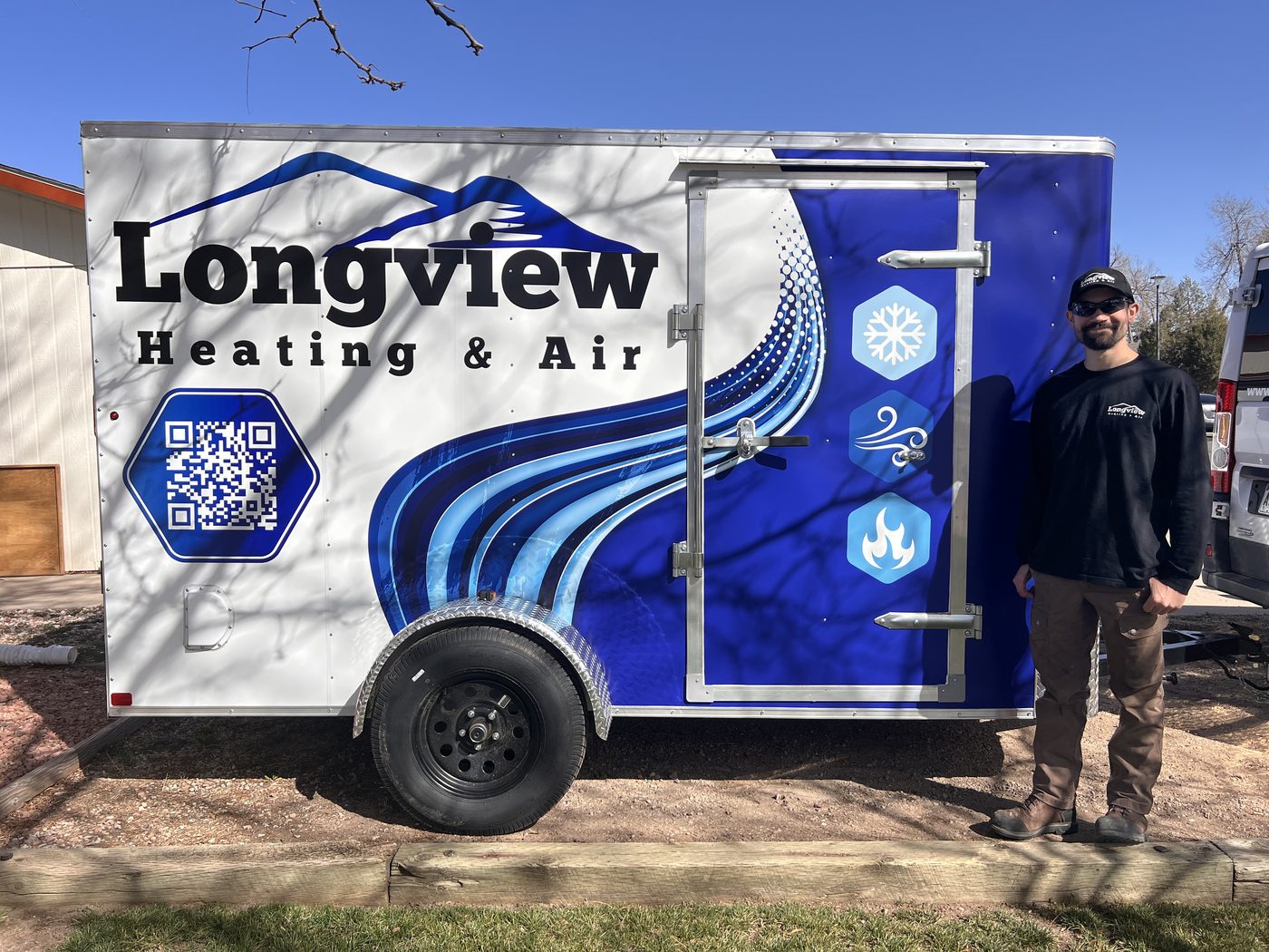 Longview Heating & Air owner with the company's branded equipment trailer